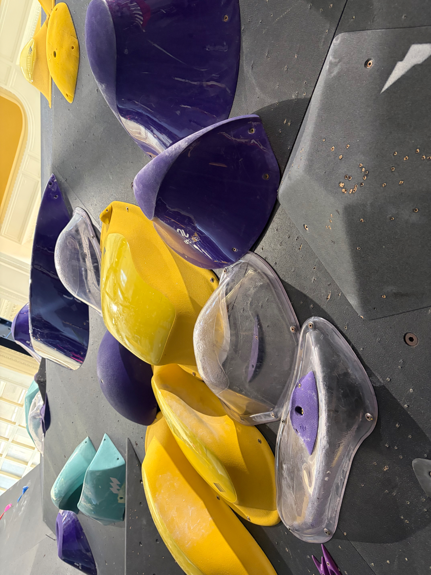 Modern competition-style climbing holds and volumes bolted to a bouldering wall at Boulder Union