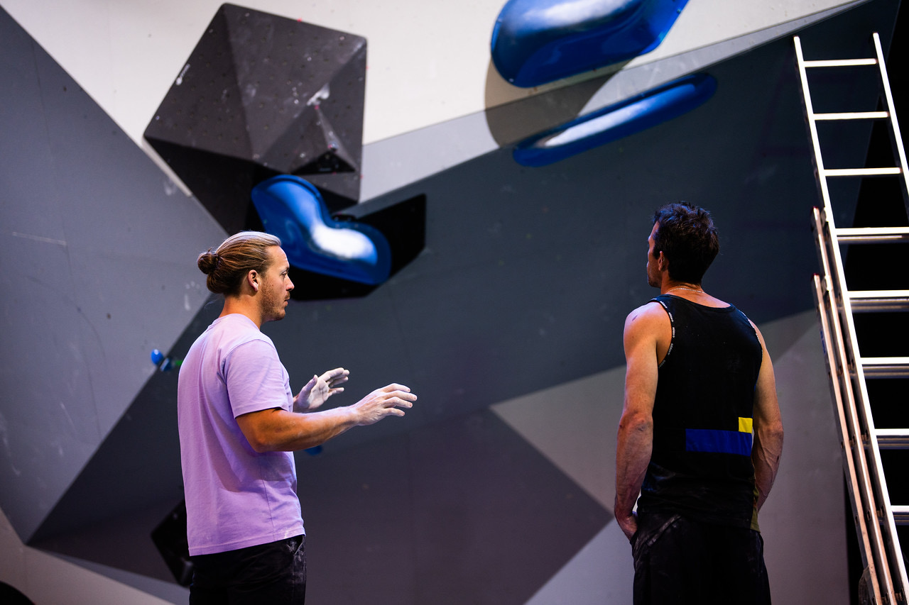 Cody Grodzki breaking down a boulder problem with an athlete during a private coaching session